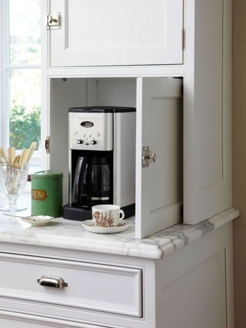 un minuscolo mobiletto con macchina per il caffè, tazze e zucchero è una vera mini stazione del caffè che si adatta a qualsiasi cucina