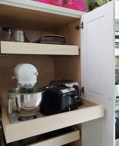 un armadio con diversi ripiani a scomparsa che contengono vari elettrodomestici ed è fantastico per ogni cucina per tenere lontano il disordine