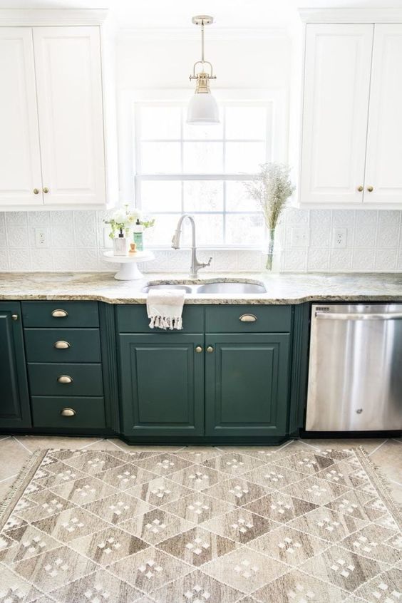 una cucina bicolore lineare in bianco e verde scuro, con ripiani in pietra e alzatina in piastrelle a motivi geometrici