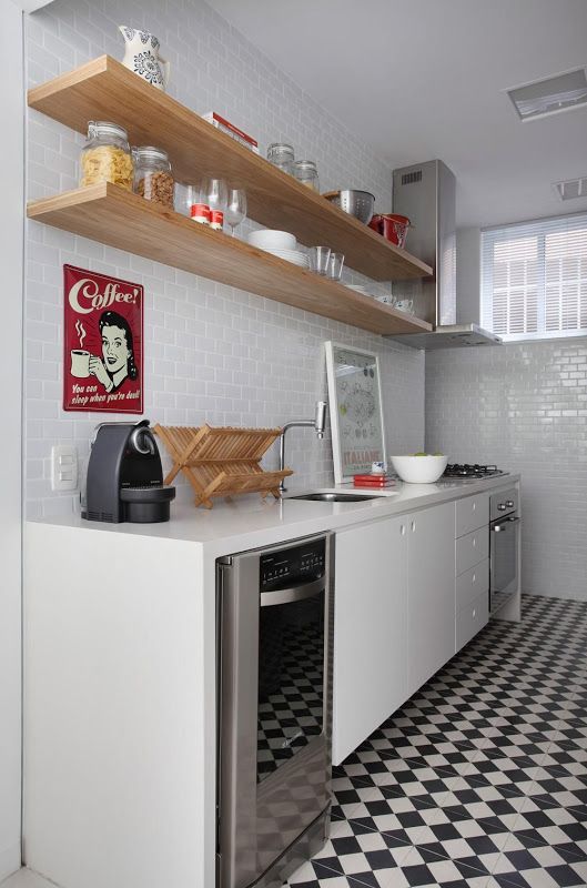 una cucina bianca semplice ed elegante a una parete con un backsplash in piastrelle bianche e un piano di lavoro in pietra bianca più un pavimento in bianco e nero