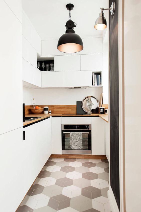 una cucina bianca contemporanea con mobili eleganti, controsoffitti macchiati di luce e un pavimento di piastrelle geometriche
