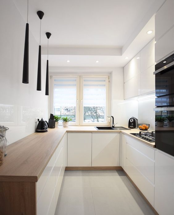 una cucina bianca minimalista con ripiani in macelleria, alzatina bianca e accattivanti lampade a sospensione nere
