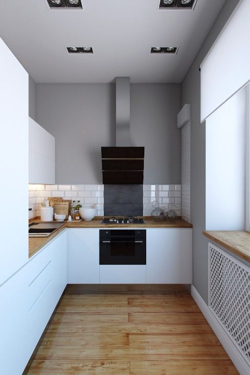 una cucina bianca minimalista con ripiani in macelleria, alzatina in piastrelle bianche ed elettrodomestici da incasso