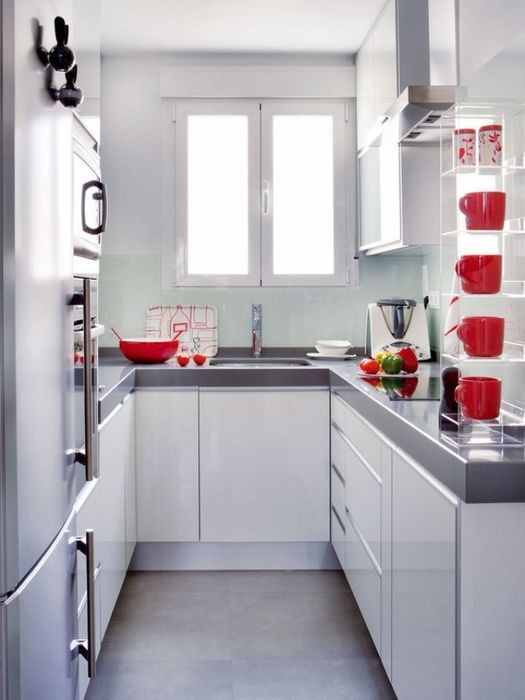 una piccola cucina bianca contemporanea con ripiani grigi e stoviglie rosse è uno spazio incantevole ed è accogliente