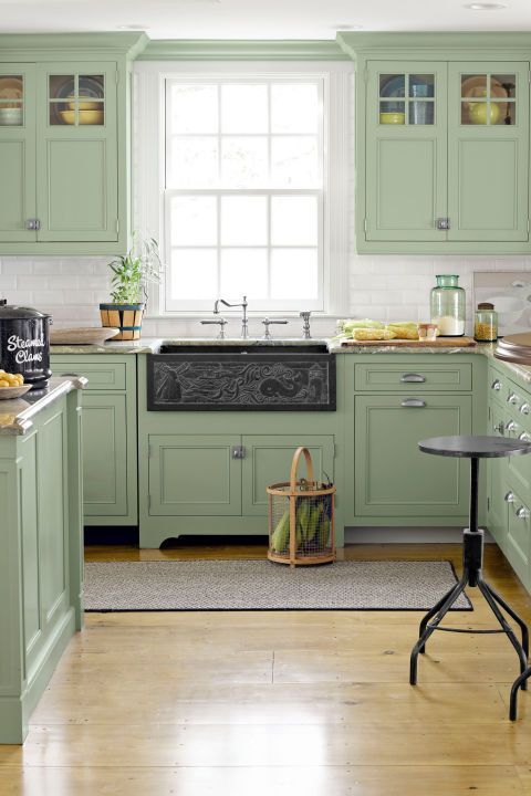 un'accogliente cucina vintage verde salvia con alzatina in piastrelle bianche, ripiani in pietra grigia e un lavandino scuro è wow