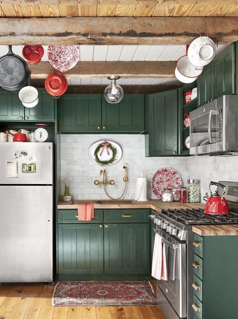 una bella cucina verde cacciatore con ripiani in macellaio e un backsplash in piastrelle di marmo bianco più travi in ​​legno sul soffitto