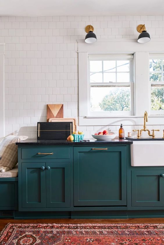 un'elegante cucina moderna verde acqua di metà secolo con ripiani neri, un muro di piastrelle bianche e tocchi d'oro qua e là