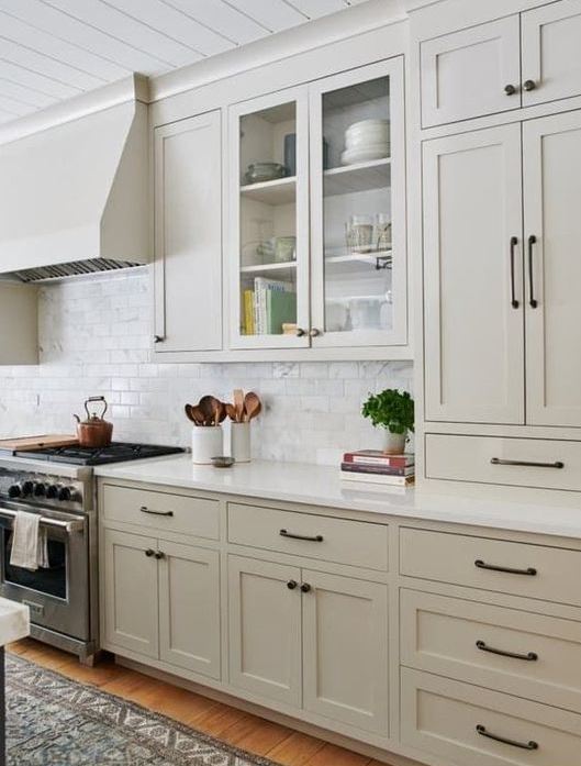 una cucina greige contemporanea con armadi vintage, maniglie nere e un backsplash in piastrelle di marmo bianco più controsoffitti bianchi