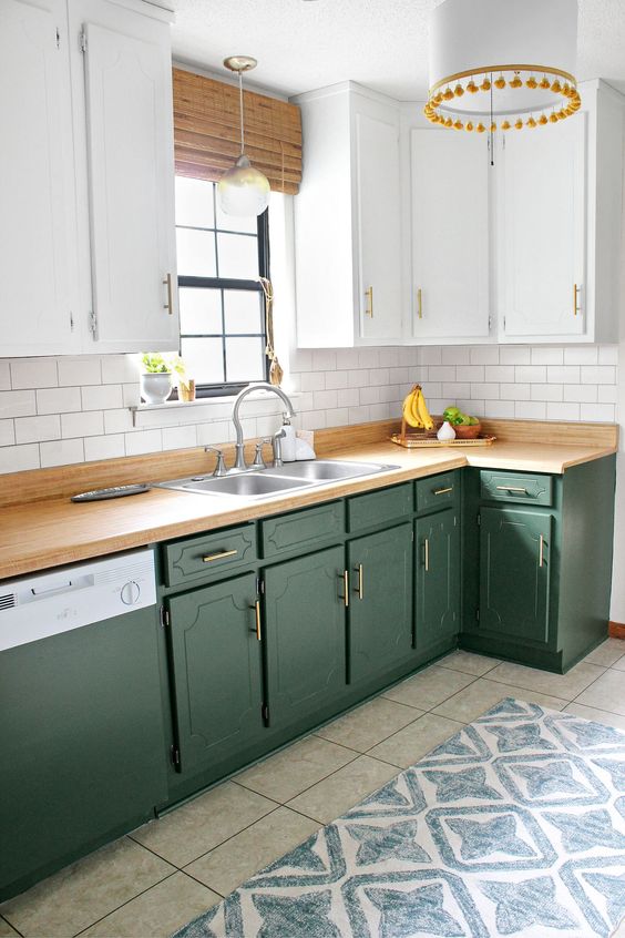 una cucina colonica bicolore con ante bianche e verdi, ripiani in macellaio e un backsplash in piastrelle bianche della metropolitana
