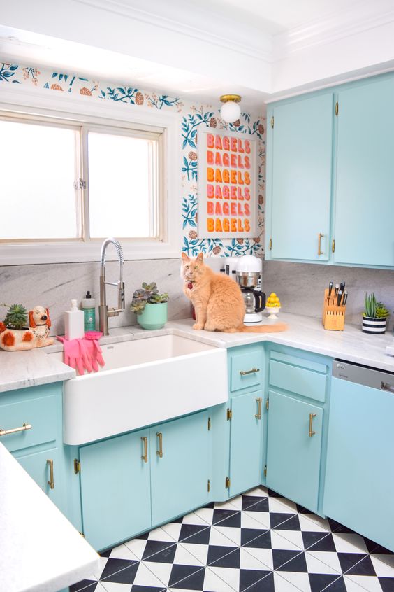 una cucina blu brillante con carta da parati stampata, un'opera d'arte colorata e un pavimento piastrellato è divertente e accogliente