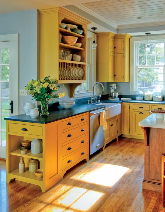 una cucina gialla solare con ripiani neri, un'isola da cucina in legno sembra molto stimolante, audace e fresca
