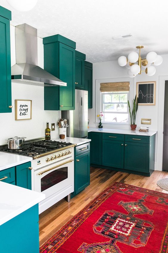 una cucina verde acqua con ripiani bianchi, un alzatina e un audace tappeto boho più una lampada retrò è una bella idea