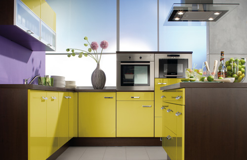 una cucina audace con armadi giallo limone e marrone, un alzatina viola ed elettrodomestici in acciaio inossidabile è moderna e audace