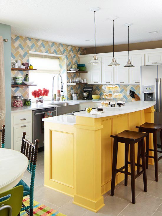 una cucina luminosa con mobili bianchi, un alzatina in piastrelle colorate e un'isola cucina gialla audace è uno spazio divertente e fresco con un'atmosfera da spiaggia