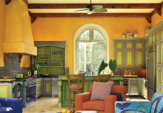 una cucina vintage colorata con mobili gialli e verdi, mobili blu, una grande cappa gialla e una sedia arancione