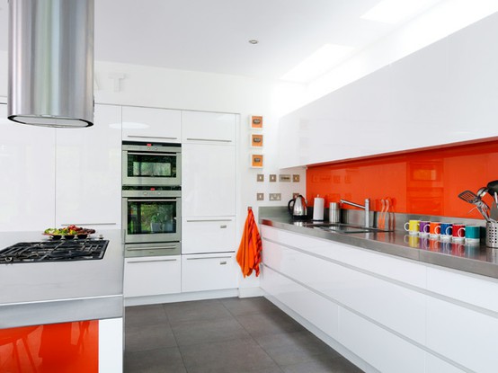 una cucina minimalista tutta bianca con tocchi arancioni audaci: un alzatina e lati per un look allegro e divertente
