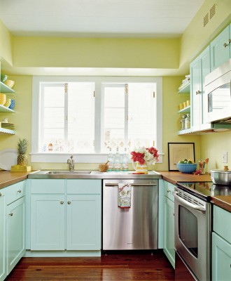 una cucina colorata con pareti gialle, armadi blu, ripiani in legno è uno spazio molto luminoso, divertente ed elegante