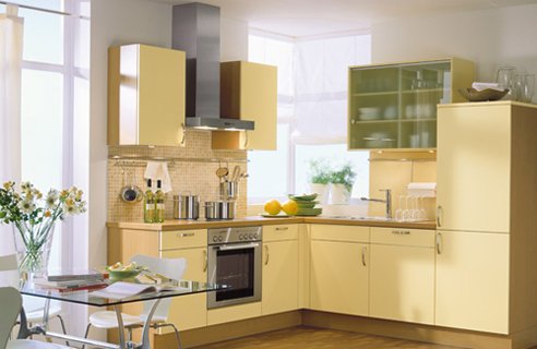 una cucina giallo pallido con ripiani in legno e un backsplash in piastrelle neutre più un tavolo in vetro è molto chic