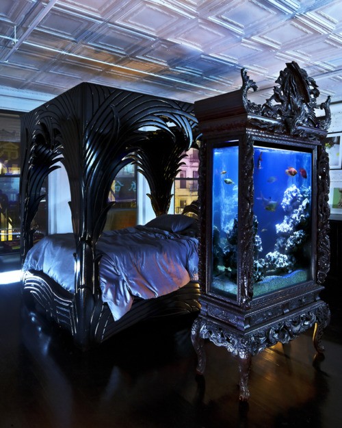 un grande acquario racchiuso in un comò nero raffinato e chic in armonia con il design della stanza