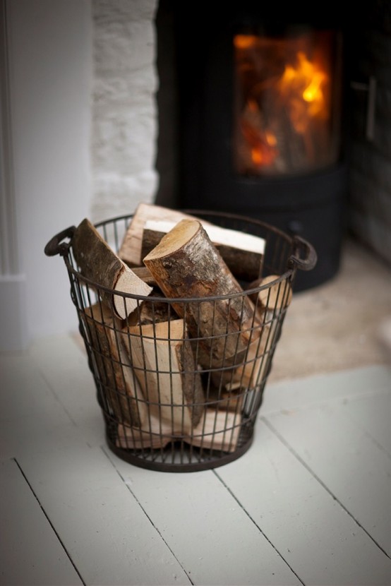 un cesto metallico con legna da ardere è una bella idea per riporlo aggiungendo intimità e un tocco vintage allo spazio