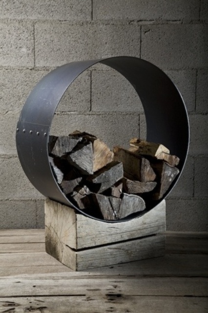 un moderno supporto per legna da ardere di un pezzo di legno grezzo e un cerchio di metallo che contiene legna da ardere è un'idea molto audace