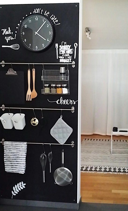 una lavagna a muro con ringhiere, supporti, ganci, un orologio e tanti appunti qua e là è l'ideale per una cucina