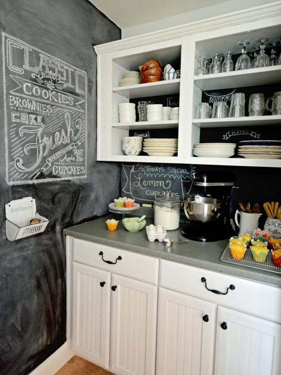 una cucina rustica neutra con una parete a lavagna e un backsplash è uno spazio elegante in cui essere e sembra molto accogliente e invitante
