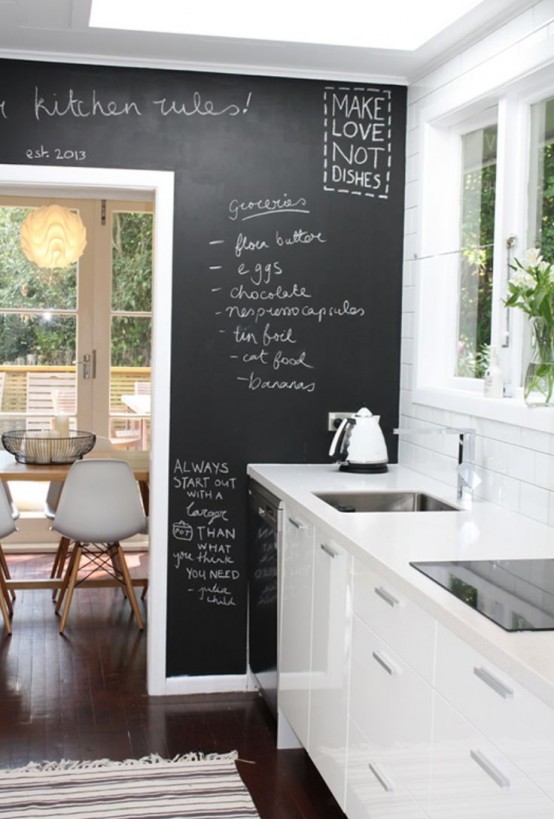 un'elegante cucina bianca e un muro di lavagna accento che può essere utilizzato per scopi pratici e aggiunge un tocco di contrasto