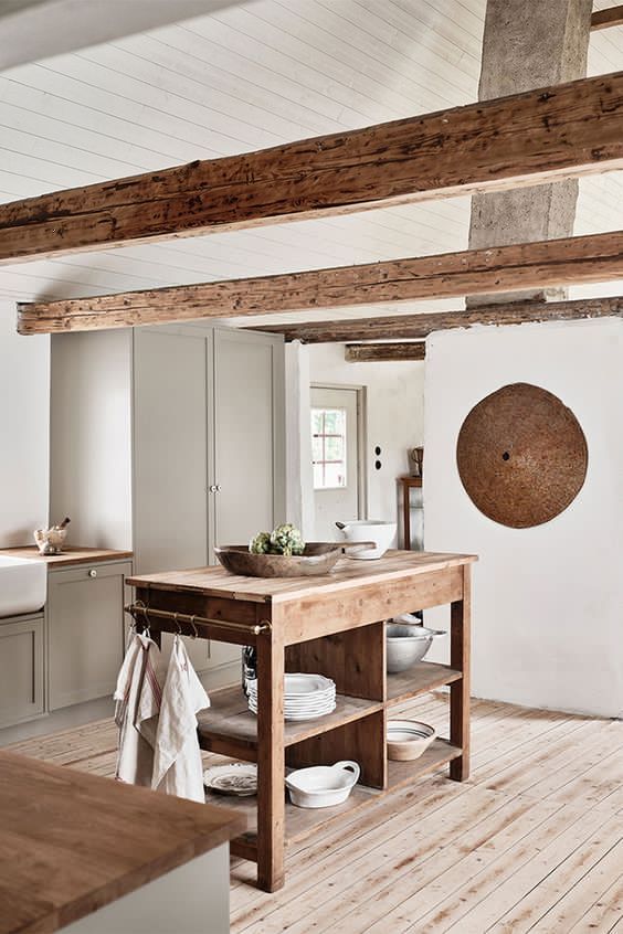 una cucina contemporanea neutra in bianco e tortora, un'isola cucina in legno, travi in ​​legno per un'atmosfera accogliente