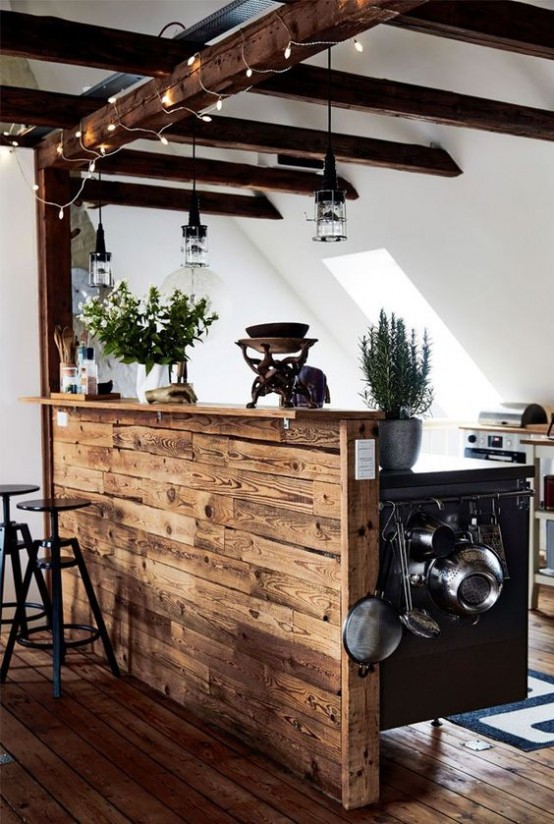 una cucina neutra contemporanea con ante bianche, un'isola cucina in legno, travi in ​​legno con lampade e luci che si abbinano e aggiungono intimità allo spazio