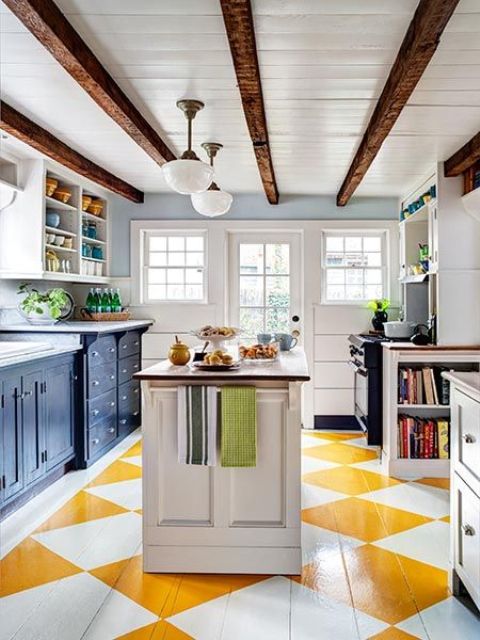 una cucina eclettica luminosa con mobili inferiori scuri e pensili bianchi, un pavimento geometrico luminoso, travi in ​​legno scuro sul soffitto per un tocco tradizionale