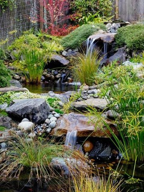 un elegante cortile giapponese con cascate, rocce, ciottoli, vegetazione e muschio intorno per un'atmosfera rilassante e calmante