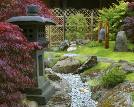 erba verde, ciottoli, rocce, aceri rossi, una lanterna di pietra e una grande campana creano un aspetto molto bello e zen