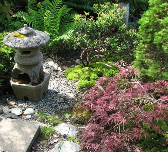 muschio, rocce, ciottoli, arbusti, piccoli alberi e una lanterna giapponese in pietra per un incantevole giardino giapponese