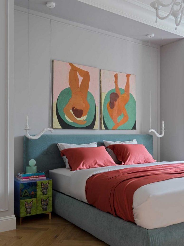 La camera da letto sfoggia un letto imbottito grigio, comodini colorati e opere d'arte audaci