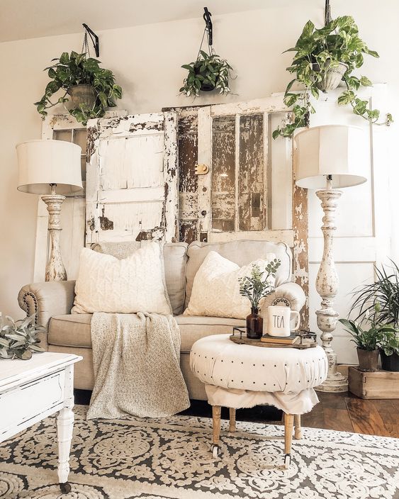un soggiorno shabby chic neutro con mobili eleganti, vegetazione in vaso, persiane shabby e lampade da terra alte