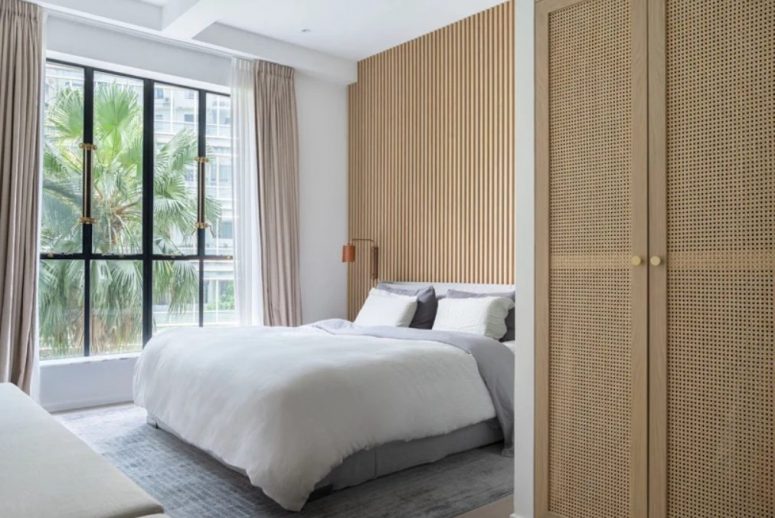 La camera da letto principale è realizzata con una parete vetrata, una parete in lastre di legno e biancheria delicata