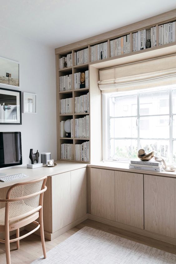 una libreria in compensato di colore chiaro con molti spazi di archiviazione chiusi è un'idea moderna e fresca per un ufficio a casa