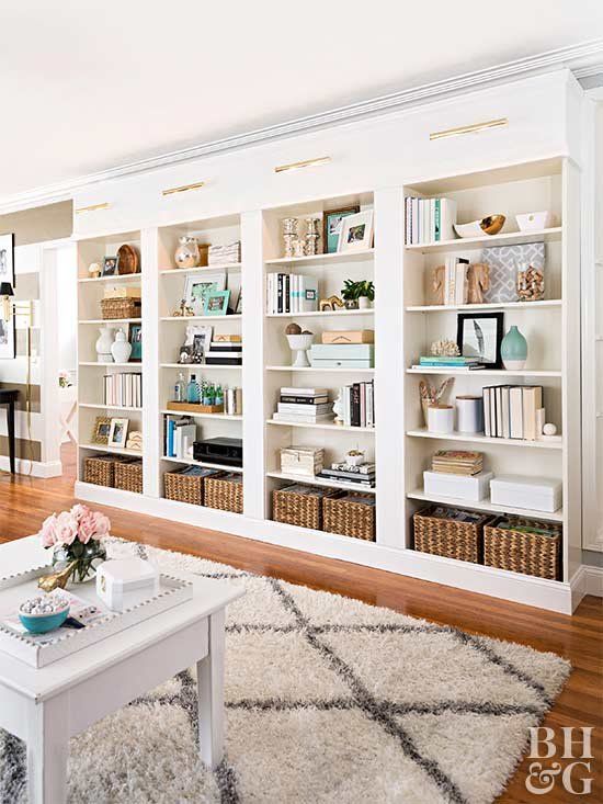 una grande libreria incorporata con molti libri, vasi, cestini e candele è una bella idea per un ufficio a casa