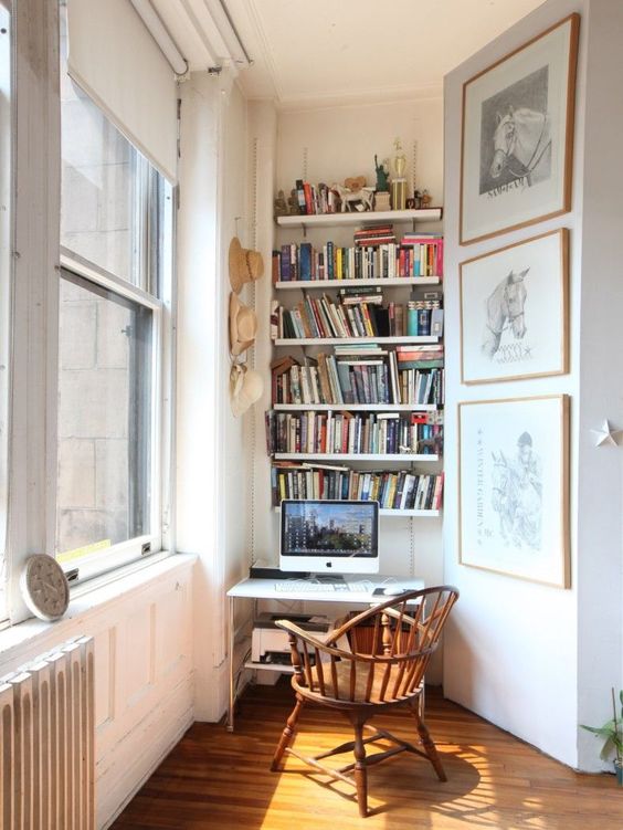 un piccolo angolo di lavoro con librerie incorporate, una piccola scrivania e una sedia vintage è uno spazio eclettico alla moda