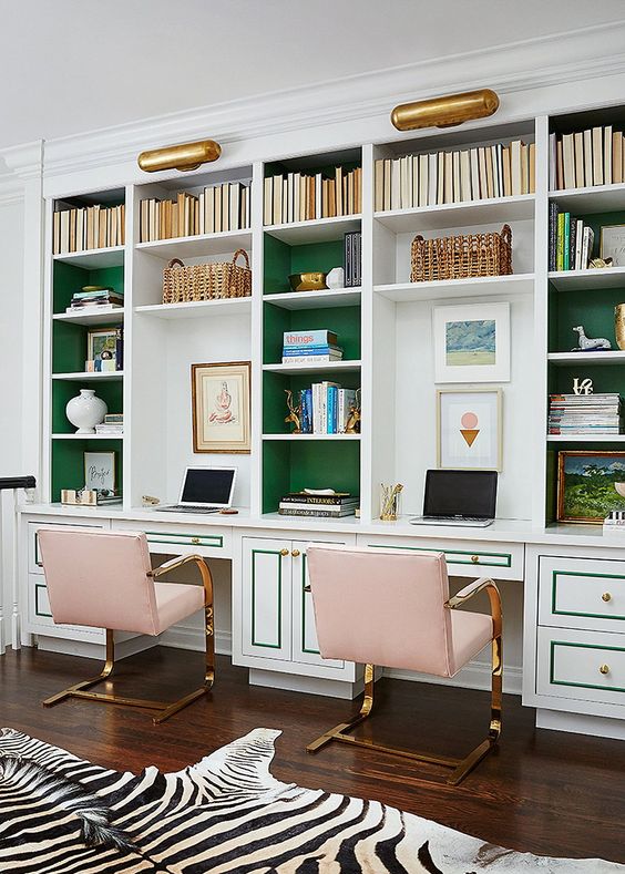 un raffinato ufficio in casa con librerie incorporate con schienale verde e sedie metalliche rosa e un finto tappeto zebrato