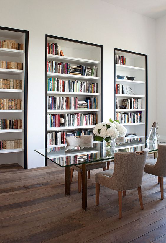 un ufficio domestico super raffinato con scaffali per libri incorporati con cornice nera per accentuarli il più possibile