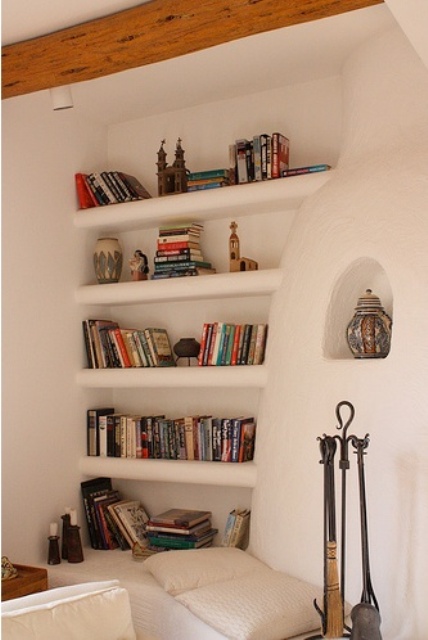 un muro di cemento bianco con scaffali incorporati dove puoi posizionare libri e altre cose che desideri
