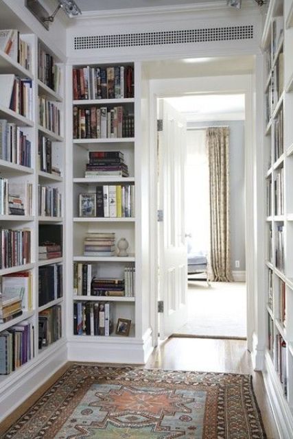 un corridoio con scaffali per libri incorporati su entrambi i lati è un'idea elegante che farà risparmiare molto spazio e conserverà tutti i tuoi libri