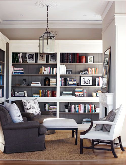 un soggiorno neutro con scaffali per libri incorporati su due pareti accanto al caminetto è un'idea molto elegante e alla moda