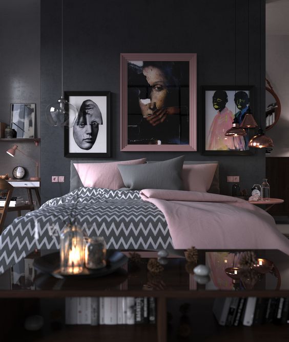 una camera da letto audace e chic con pareti nere, un letto grigio, biancheria da letto grigia e rosa, lampade a sospensione in oro rosa e tocchi rosa