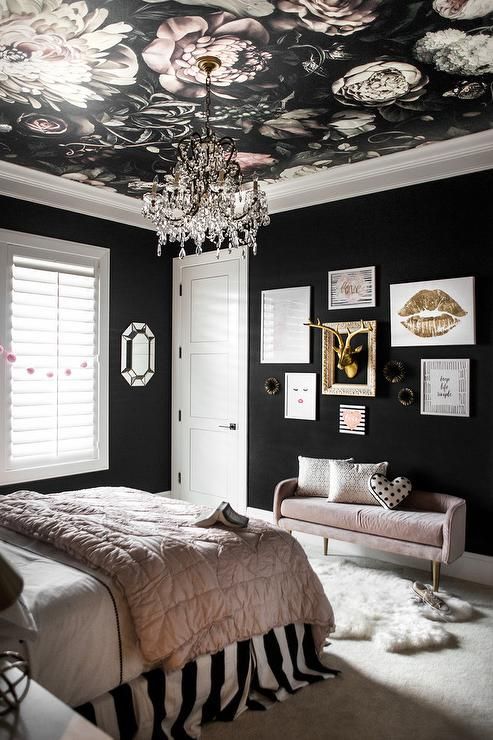 una moderna camera da letto glam con pareti nere, un soffitto floreale, fard e biancheria da letto nera e una galleria a parete chic
