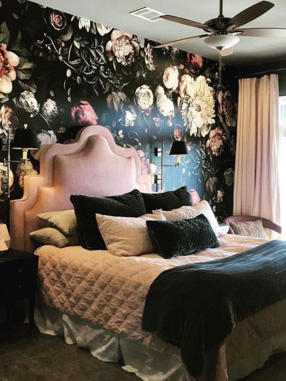 una camera da letto squisita con un muro floreale, un letto e una sedia rosa, tende arrossate, biancheria da letto bianca e nera
