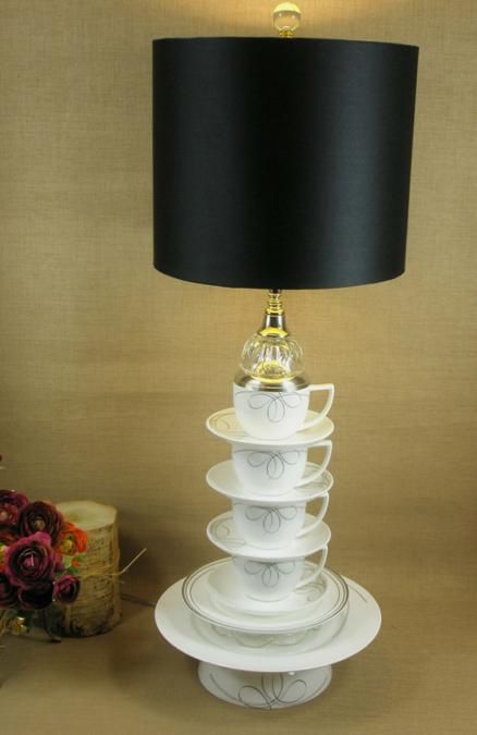una lampada da tavolo nera con una base fatta di accessori da tè e un elegante paralume nero è un'idea interessante con un tocco bizzarro, ricorda Alice nel paese delle meraviglie