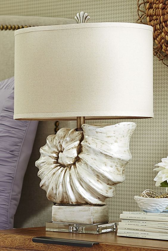 una lampada da tavolo con una conchiglia di grandi dimensioni e un semplice paralume è una splendida idea per qualsiasi spazio sulla spiaggia